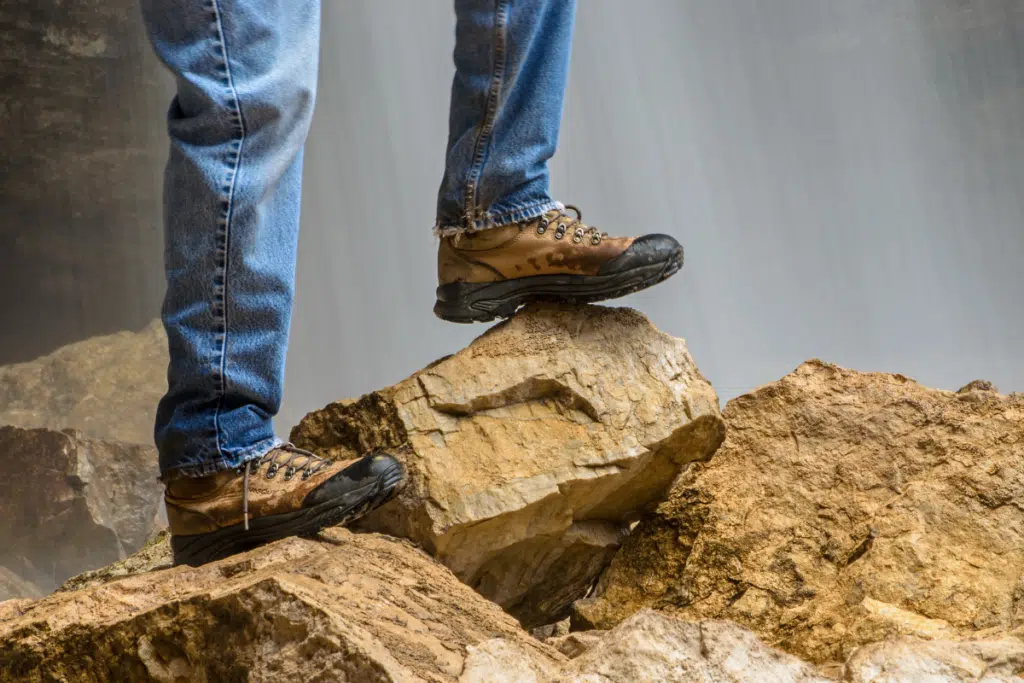 Man using hiking boots for hiking in uneven terrain. 
