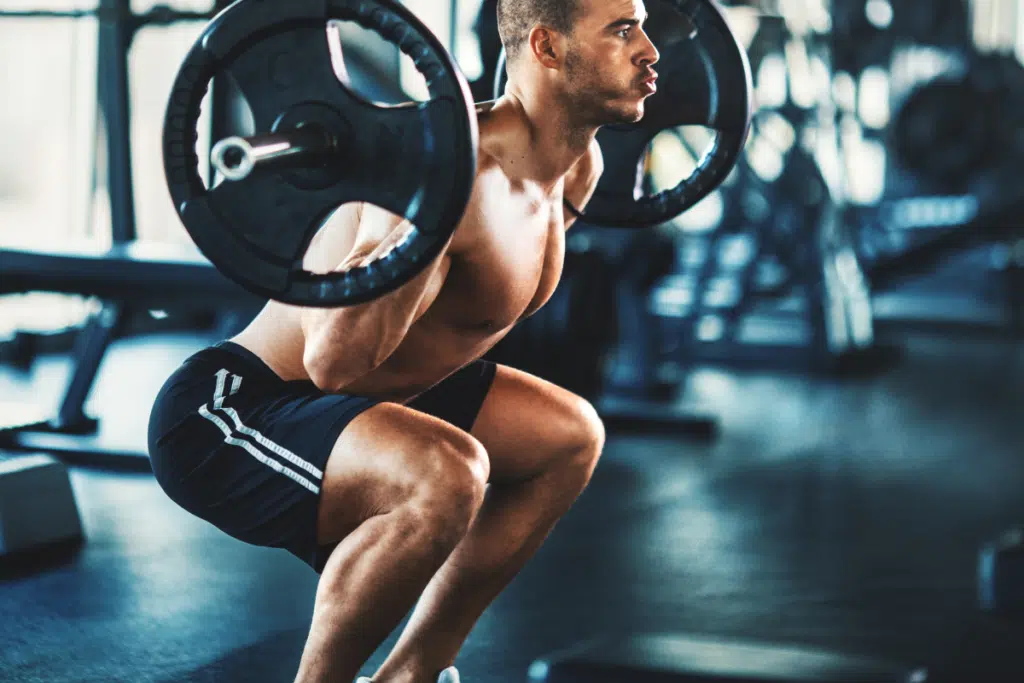 man squatting with a barbell