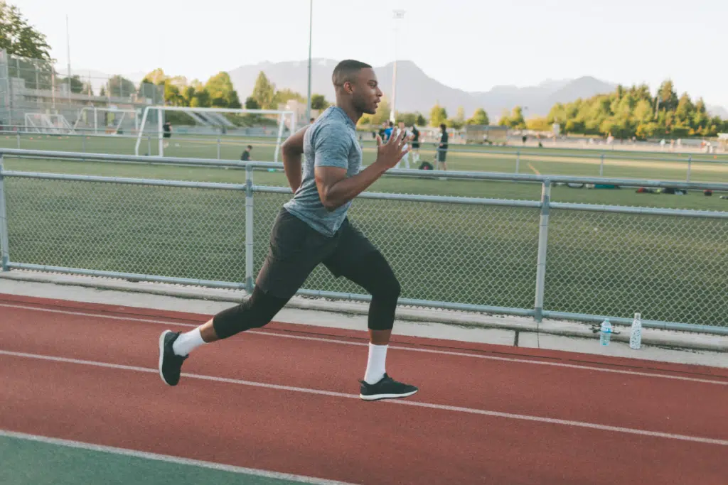 man running around a track after strength training