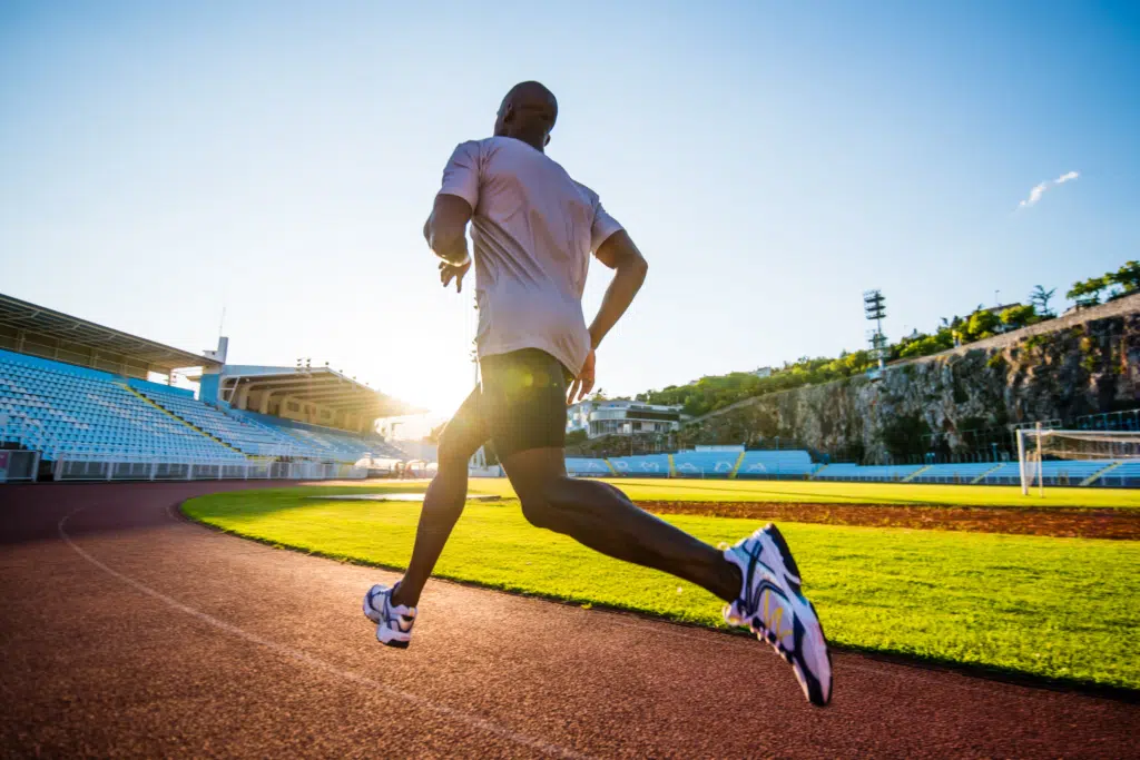man running around a track in hot weather