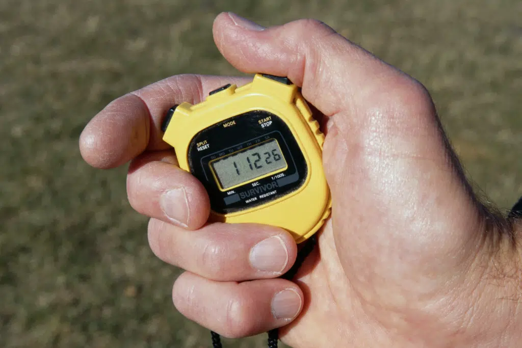 Man using a stopwatch to measure running metrics