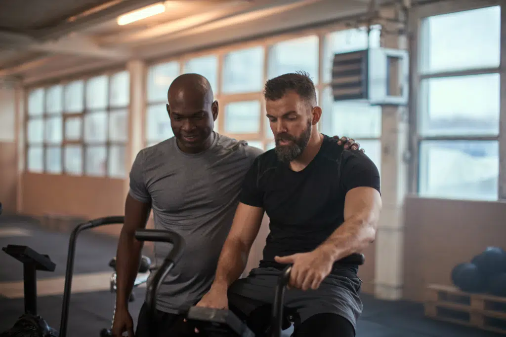 two men training on a stationary bike