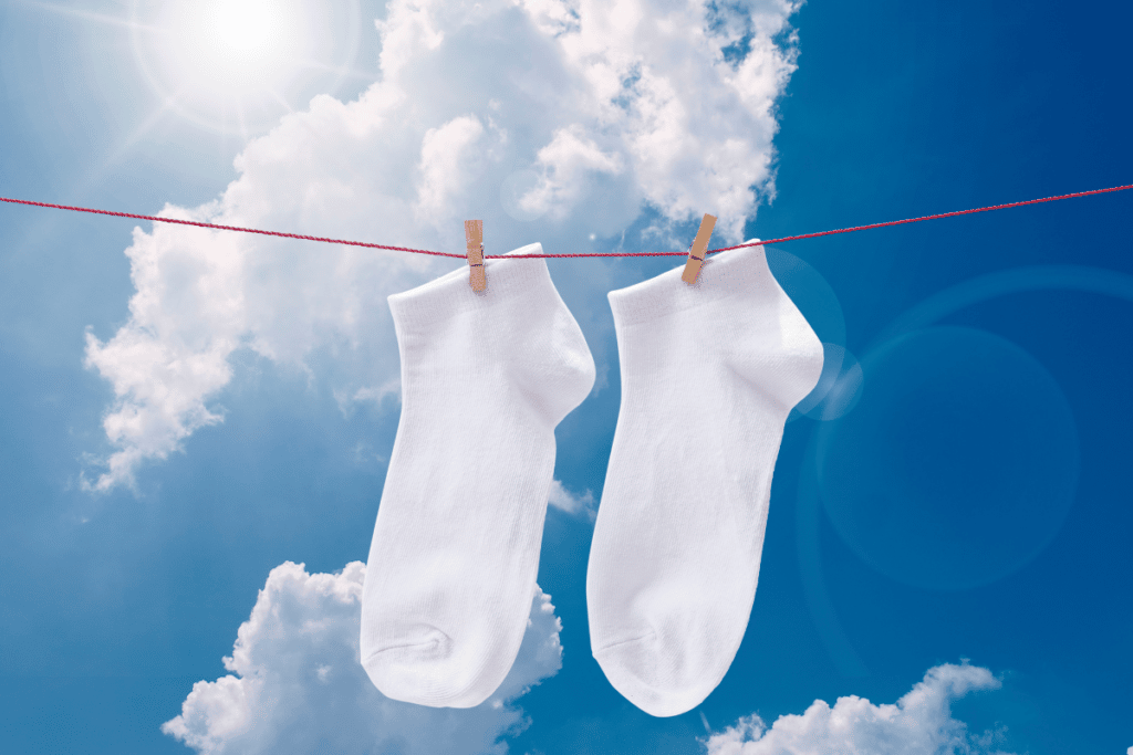 Air dry your socks after washing to help prevent persistent smells. Air drying in the sun can help kill lingering bacteria and even whiten your laundry.